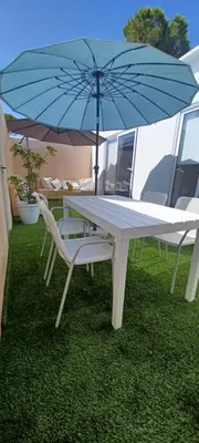 a white table and chairs with an umbrella at Casita de diseño cerca del mar in El Puerto de Santa María
