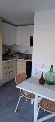 a white kitchen with a white table and chairs at Casita de diseño cerca del mar in El Puerto de Santa María