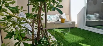 a room with a couch and a table with green carpet at Casita de diseño cerca del mar in El Puerto de Santa María