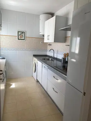a white kitchen with a sink and a refrigerator at Apartamento Centro Chipiona La Perla in Chipiona