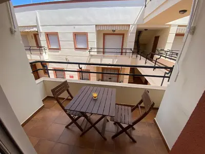 a balcony with a table and chairs on a ship at Apartamento Centro Chipiona La Perla in Chipiona