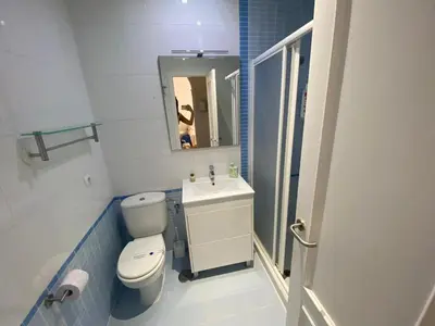 a bathroom with a toilet and a sink and a mirror at Apartamento Centro Chipiona La Perla in Chipiona