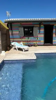 a swimming pool with a bench and a house at La Casita in Cuartillos