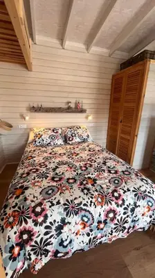 a bedroom with a bed with a floral comforter at La Casita in Cuartillos