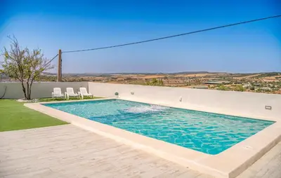 a swimming pool with two chairs on the side of a house at Nice Home In Arcos De La Frontera in Arcos de la Frontera
