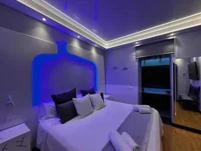 a purple bedroom with a large bed with pillows at BASTINAZO ALOHADREAM - EXCLUSIVO - Design Suite Luxury Love and Spa - Jacuzzi y Sauna Privados in El Puerto de Santa María
