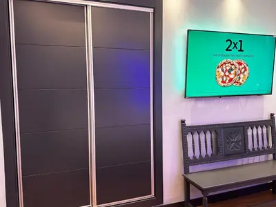 a closet with a tv on a wall next to a bench at BASTINAZO ALOHADREAM - EXCLUSIVO - Design Suite Luxury Love and Spa - Jacuzzi y Sauna Privados in El Puerto de Santa María