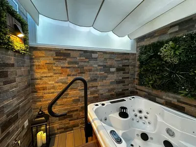 a jacuzzi tub in a room with bricks at BASTINAZO ALOHADREAM - EXCLUSIVO - Design Suite Luxury Love and Spa - Jacuzzi y Sauna Privados in El Puerto de Santa María