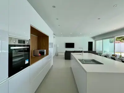 a white kitchen with a stove and a couch at El Nirvana in Chiclana de la Frontera