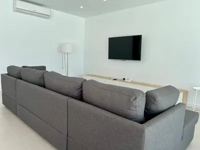 a gray couch in a living room with a tv at El Nirvana in Chiclana de la Frontera