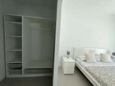 a white bedroom with a bed and a closet at El Nirvana in Chiclana de la Frontera