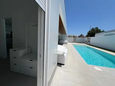 a bathroom with a swimming pool next to a house at El Nirvana in Chiclana de la Frontera