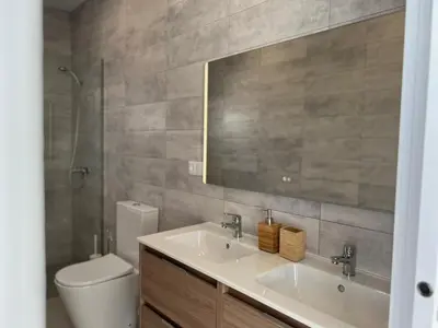 a bathroom with two sinks and a toilet and a mirror at El Nirvana in Chiclana de la Frontera