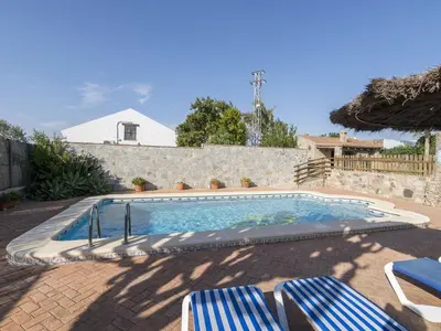 a swimming pool with two lawn chairs at Holiday Home De Piedra by Interhome in Conil de la Frontera