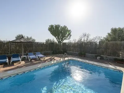 a swimming pool with two chairs and a fence at Holiday Home De Piedra by Interhome in Conil de la Frontera