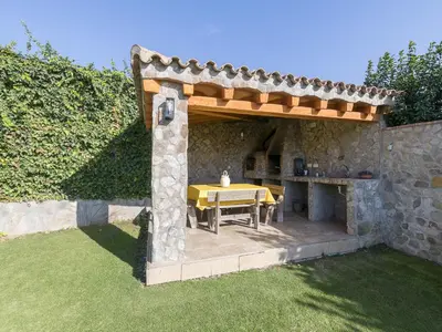 a patio with a table under a wooden pergola at Holiday Home De Piedra by Interhome in Conil de la Frontera