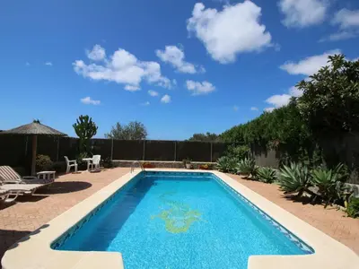 a swimming pool in a backyard with a blue sky at Holiday Home De Piedra by Interhome in Conil de la Frontera