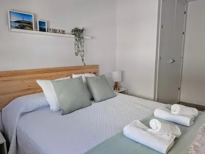 a bedroom with a bed with towels on it at Apartamento Costa de la Luz in Chiclana de la Frontera