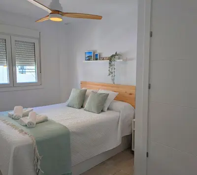 a bedroom with two beds and a ceiling fan at Apartamento Costa de la Luz in Chiclana de la Frontera