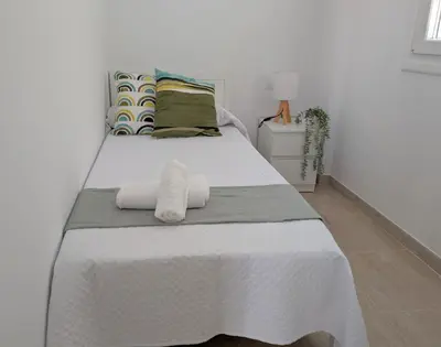 a bedroom with a bed with two towels on it at Apartamento Costa de la Luz in Chiclana de la Frontera