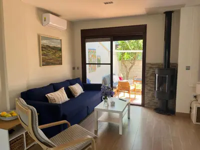a living room with a blue couch and a table at Casa con encanto El Manatial in El Puerto de Santa María