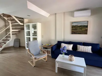 a living room with a blue couch and a stairs at Casa con encanto El Manatial in El Puerto de Santa María