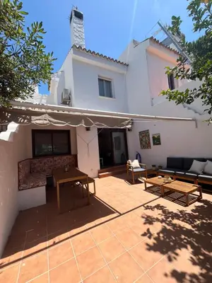 a patio in front of a white house at Casa con encanto El Manatial in El Puerto de Santa María