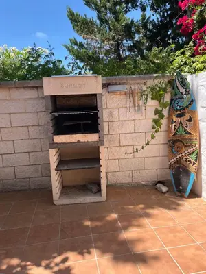 a brick oven with a surfboard leaning against a wall at Casa con encanto El Manatial in El Puerto de Santa María