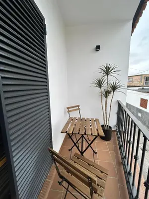 a balcony with a wooden bench and a table at Casa Mariquilla in Sanlúcar de Barrameda