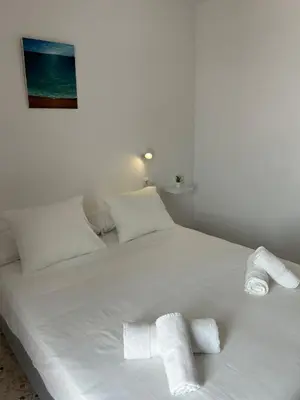 a white bed with two white towels on it at Casa Mariquilla in Sanlúcar de Barrameda