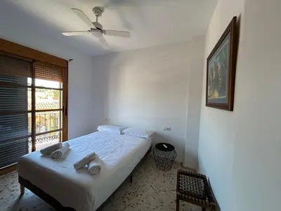 a bedroom with a bed and a ceiling fan at Casa Mariquilla in Sanlúcar de Barrameda