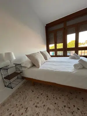 a bedroom with a large white bed with a window at Casa Mariquilla in Sanlúcar de Barrameda
