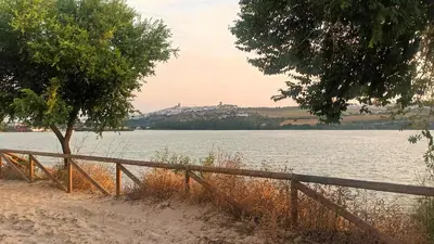 a wooden fence next to a body of water at Casa 1 dormitorio con piscina privada y jardin in Arcos de la Frontera