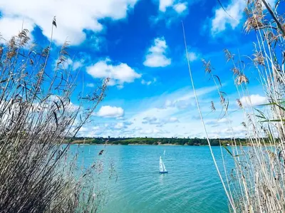 a sailboat in the water on a lake at Casa 1 dormitorio con piscina privada y jardin in Arcos de la Frontera