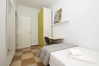 a small bedroom with a bed and a desk at Velbar in Cádiz