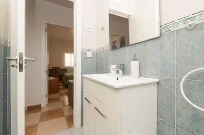 a white bathroom with a sink and a mirror at Velbar in Cádiz