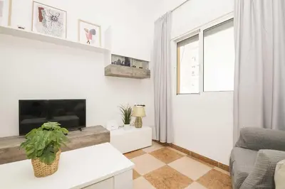 a white living room with a fireplace and a couch at Velbar in Cádiz