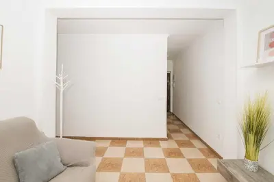 a living room with a couch and a checkered floor at Velbar in Cádiz