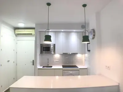 a kitchen with white cabinets and a white counter top at Apartmento Apartaclub La Barrosa 223 in Chiclana de la Frontera