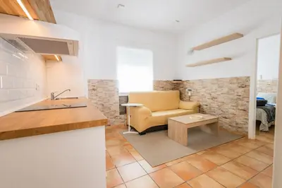 a kitchen with a couch and a chair in a room at GuestReady - Calvario Rota 30 JC in Rota