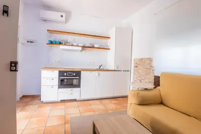 a living room with a couch and a kitchen at GuestReady - Calvario Rota 30 JC in Rota