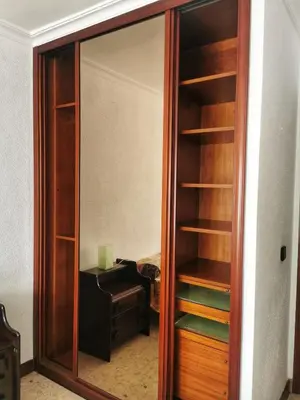 a closet with a glass door next to a desk at Apartamento primera linea de playa in Cádiz