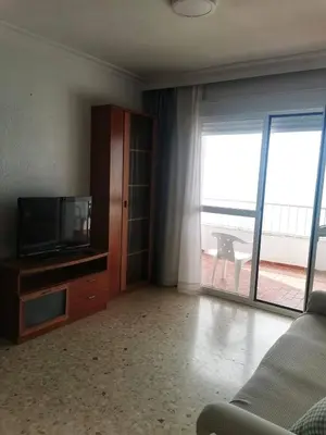 a living room with a flat screen tv and a couch at Apartamento primera linea de playa in Cádiz