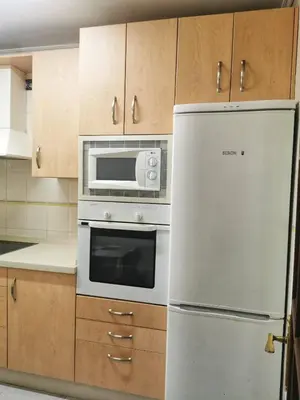 a kitchen with a white refrigerator and a microwave at Apartamento primera linea de playa in Cádiz