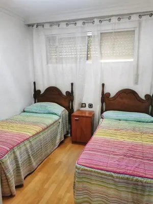 a bedroom with two beds and a window at Apartamento primera linea de playa in Cádiz
