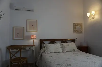 a bedroom with a bed and a table with a chair at Montserrat Casa del Mar in Chipiona