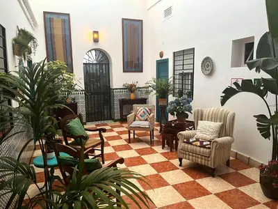 a living room with chairs and a checkered floor at Montserrat Casa del Mar in Chipiona