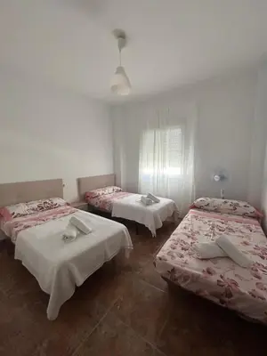three beds in a room with white walls at Barrameda 15 con parking in Sanlúcar de Barrameda