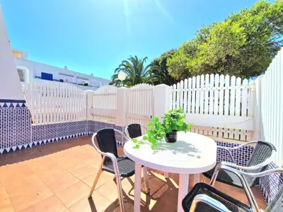 a patio with a white fence and a table and chairs at La almadraba in Chiclana de la Frontera