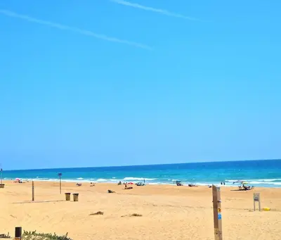 a beach with a lot of people and the ocean at La almadraba in Chiclana de la Frontera